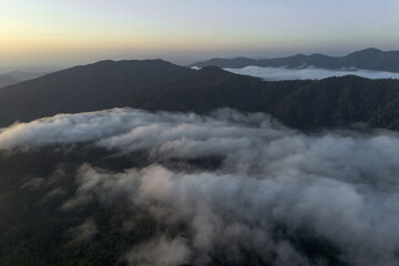 Serene aerial view over mountain range at sunrise. tranquil sea of cloud fills deep valley below, creating peaceful and majestic landscape feeling of freedom