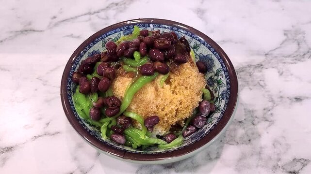 Cendol is a Malaysian dessert made of shaved ice, coconut milk, green pandan jelly noodles, and sweet dark brown sugar syrup (Melaka Sugar).