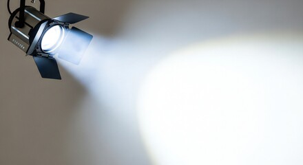 Elegant spotlight shining brightly on neutral backdrop creates dramatic impact perfect for stage presentations or film production needs