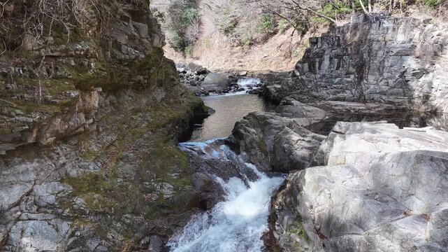 Aerial footage retreating toward the grand Kido River waterfall. Captured close-up for powerful motion and rich water flow. Perfect for outdoor, nature, or adventure video projects.