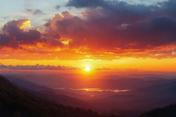 Vibrant sunset over layered mountain ranges with glowing orange and purple clouds illuminating the sky and valleys beneath