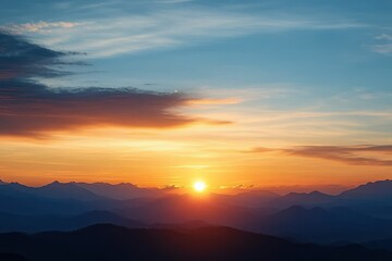 Obraz premium Beautiful sunrise over layered mountain ranges with colorful sky and scattered clouds creating a peaceful and serene morning atmosphere
