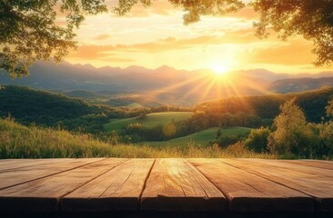 Fototapeta premium Sunset view over rolling green hills and distant mountains framed by tree branches with wooden surface in the foreground and warm golden light
