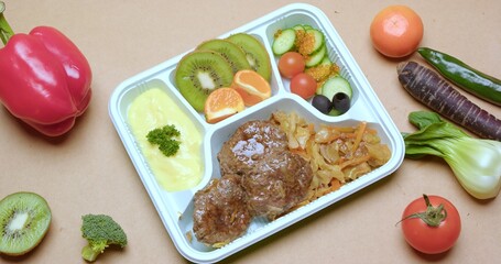 Delicious and Healthy Bento Box Meal with Rice and Orange Juice