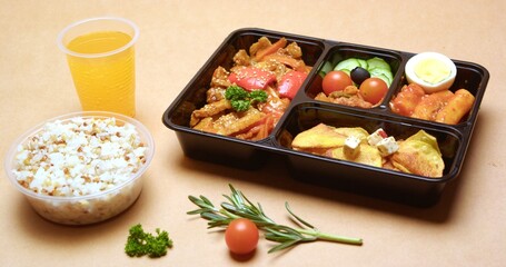 Delicious and Healthy Bento Box Meal with Rice and Orange Juice