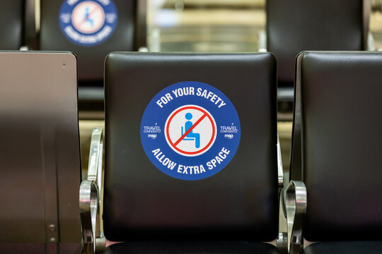 Minneapolis, Minnesota \ USA - 22 April 2021: Airport terminal seating with COVID-19 social distancing safety stickers at MSP