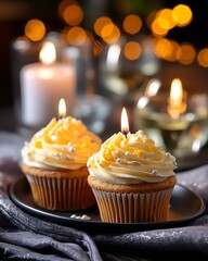 Decorative cupcakes with yellow frosting and candles on a festive table setting