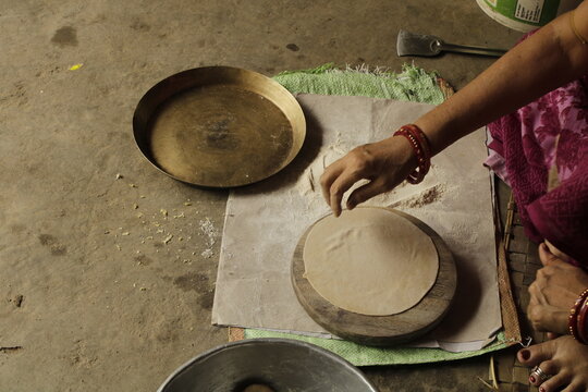 Indian Woman Rolling Roti or Chapati Dough with Wooden Rolling Pin on Chakla, Traditional Indian Cooking, Homemade Flatbread Preparation and Food Culture