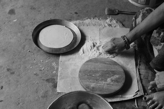 Indian Woman Rolling Roti or Chapati Dough with Wooden Rolling Pin on Chakla, Traditional Indian Cooking, Homemade Flatbread Preparation and Food Culture