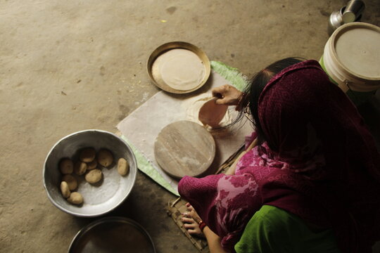 Indian Woman Rolling Roti or Chapati Dough with Wooden Rolling Pin on Chakla, Traditional Indian Cooking, Homemade Flatbread Preparation and Food Culture