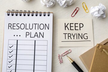 Flat Lay of a Solution Plan Notebook and Keep Trying Note