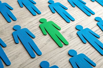 Green human figure standing out among blue icons
