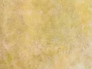 Decorative yellow gold textured paint on a wall or panel. yellow washed paint with random brush strokes, grunge, and dirt pattern. Seamless background texture.