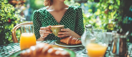 The woman enjoying a relaxed outdoor breakfast with coffee and croissant in garden