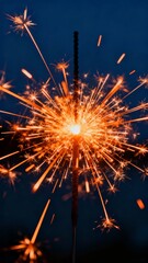 Obraz premium A vibrant sparkler bursts with golden sparks against a deep blue night sky, creating a dazzling display of light and motion.
