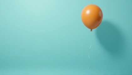 Single orange balloon floating in soft sunlight against a turquoise wall, creating a calm and modern minimalist composition