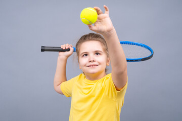 Child holds tennis racket and tennis ball on isolated studio background. Sport child play tennis. Sports training kid concept. Healthy kids lifestyle with tennis.