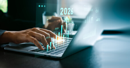 Businessman analyzing digital financial growth charts with upward trends and 2026 target, using laptop and stylus for strategic planning, investment forecasting, future business performance analysis