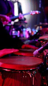 Drumming scene with lively ambiance, Energetic conga performance in colorful club, Vivid club environment showcasing percussionists and guitars in energetic motion