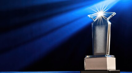 Shiny acrylic award trophy illuminated on a dark blue stage