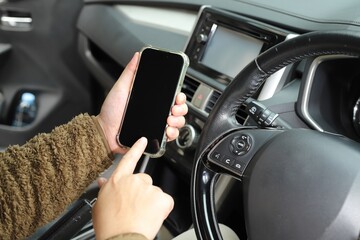 Mockup of driver hand using smartphone in car.