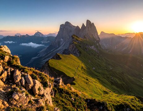Scenic mountain range at sunrise, sun shining over the jagged peaks