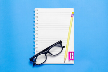 Empty notebook arranged on blue background.