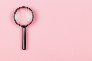 Magnifying glass on a pink background for clear detail observation