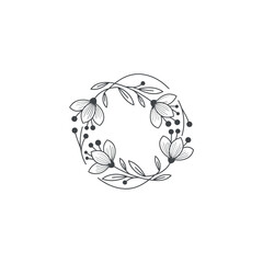 Delicate floral wreath design featuring stylized flowers and leaves arranged symmetrically.