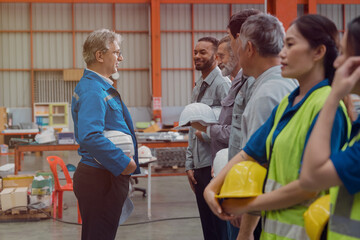 A group of engineers and staff members are discussing their work while working in a metal sheet and metal sheet roofing factory.
