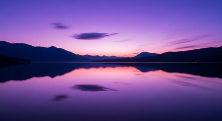 Fototapeta premium A breathtaking purple and orange twilight descends over a calm mountain lake, creating a stunning reflection of the vibrant sky on the water's surface, evoking a sense of peaceful tranquility