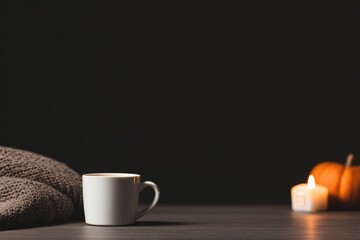 Warm drink beside cozy blanket and candles creates inviting autu