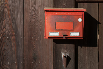 Red mailbox on wooden wall of Japanese home at Kitsuki town, Oita