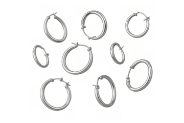 Silver hoop earrings scattered on transparent background, showcasing minimalist jewelry fashion and sleek design