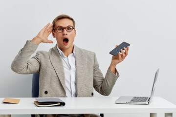 surprised man using smartphone work laptop digital detox concept casual wear glasses modern office...