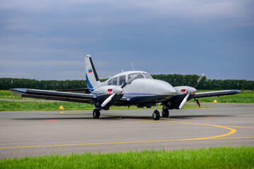 Two yellow and white airplanes are parked on a runway with a clear blue sky in the background