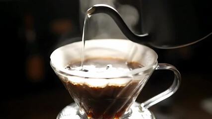 Close up of hot water being poured into a pour over coffee maker for brewing fresh coffee.