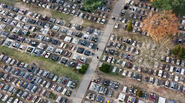 Aerial cemetery graves autumn Bydgoszcz city Poland 4K. All Saints' Day, annual night cemetery family gathering. Graves covered with flowers and lights for the dead. Funeral final destination. Modern.