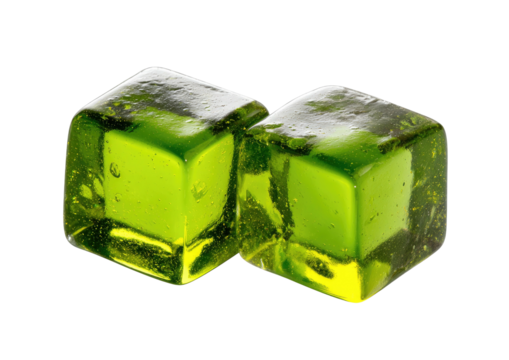 Two green ice cubes glistening on black