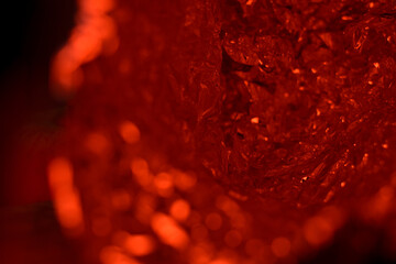 Abstract Red Foil Background with Light Reflections. Artistic red metallic foil with crumpled texture and glowing reflections, creating a modern luxury effect.