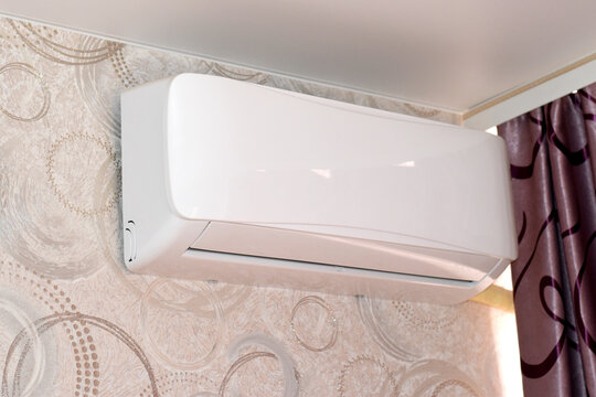 Air Conditioner Unit on Interior Wall. Close-up of a white split-system air conditioner installed in a modern room. Concept of temperature control, comfort, and efficient home cooling. - Powered by Adobe