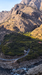 Dramatic mountain landscape with rocky peaks, lush forest, winding road, and river rapids, capturing autumn contrasts between greenery and rugged terrain.  
📍Zhivar, Hawraman Takht 