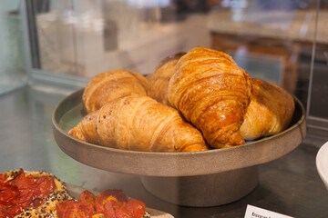 Freshly baked croissants on display in a bakery case