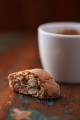 Cantuccini (Italian cookie) and a cup of coffee on dark wooden background. Close up.	