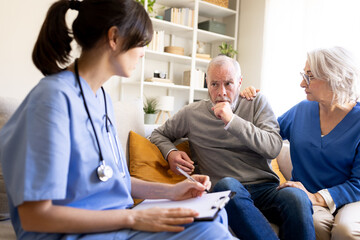 Fototapeta premium Doctor visiting senior man coughing at home with wife