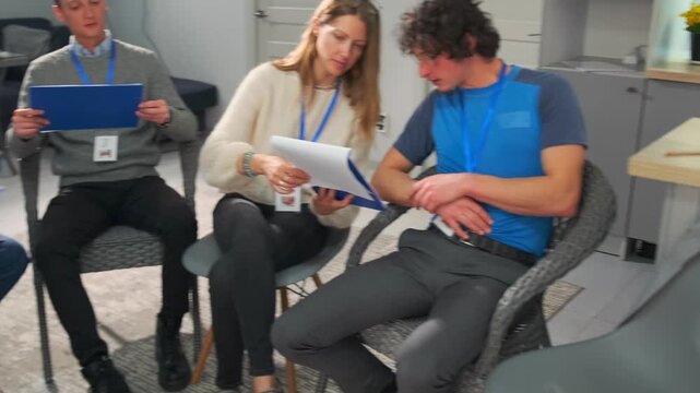 participants review printed guidelines together, corporate training with collaborative page comparison, participants collaboratively examining printed handouts in focused corporate training