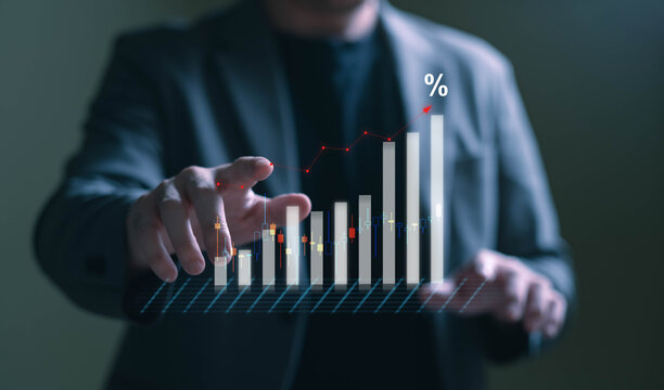 A modern business concept image illustrating economic growth, inflation, and financial data analysis. The photo shows a close-up of a person typing on a laptop keyboard with a holographic bar chart