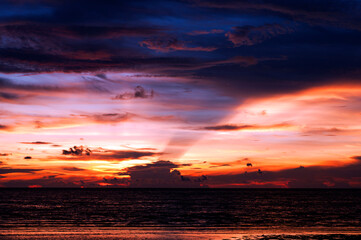As the final light fades, the beach surrenders to twilight—sky ablaze with deep hues, shadows stretch across the sea, and the day exhales its last breath in a moment of quiet beauty.