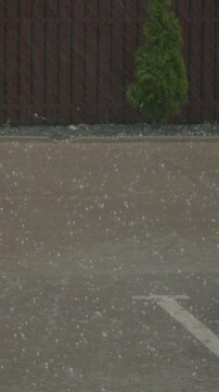 Vertical video Heavy rain and hailstorm in city parking lot causes flooding on asphalt