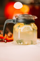 Refreshing lemon mint beverage served in a glass pitcher at a cozy gathering
